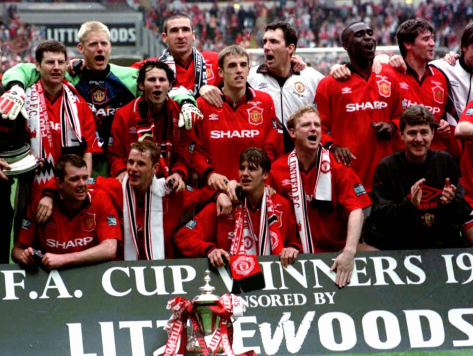 A triumphant Manchester United with the FA Cup after defeating Liverpool at London's Wembley Stadium Saturday, May 11 1996. United defeated Liverpool 1-0 after an 86th minute goal from the foot of team captain, Eric Cantona, back row, 2nd left. (AP Photo/PA-Sean Dempsey) UNITED KINGDOM OUT