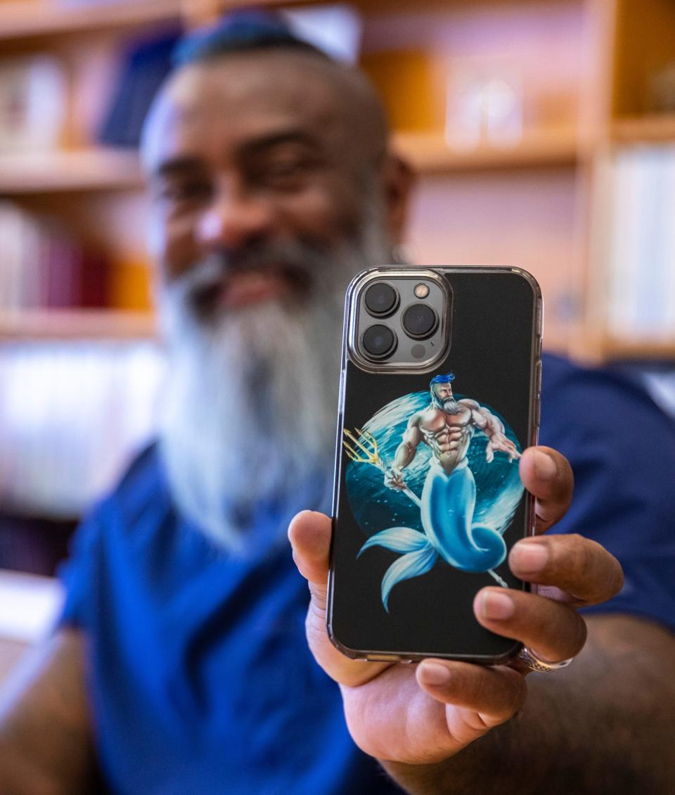 Registered Nurse André Chambers shows off his phone case with a depiction of him as Aquaman at the Betty Ford Center in Rancho Mirage, Calif., Thursday, July 6, 2023.
