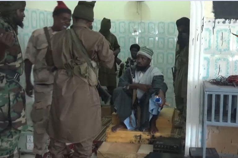 The leader of the Boko Haram Abubakar Shekau (C, seated) preaches to locals in an unidentified town in this screengrab taken on November 9, 2014 from a new video released by the militant group