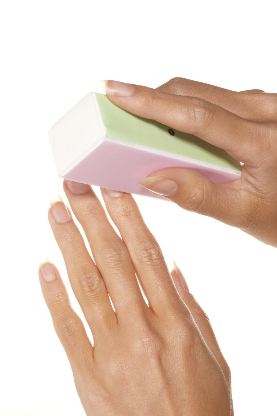 A woman buffing her clean nails with a nail buffer