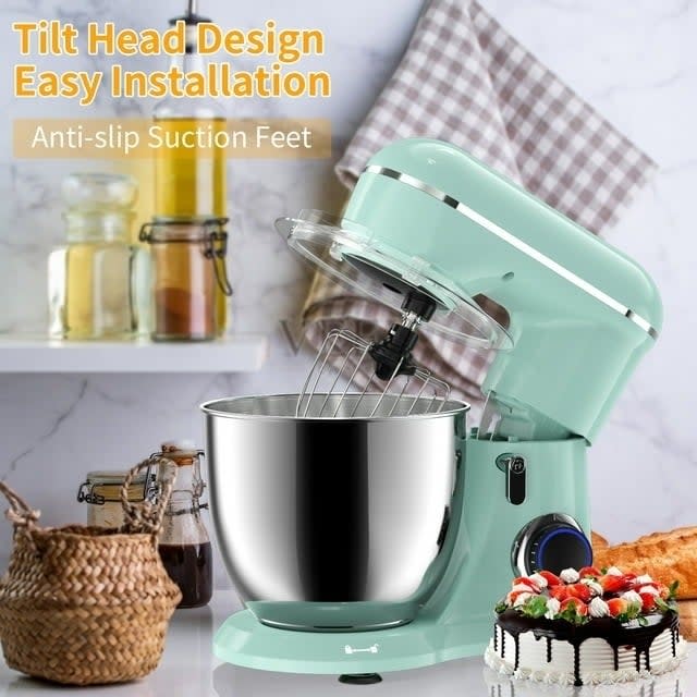 Mint green stand mixer with tilt-head design and anti-slip feet on kitchen counter beside ingredients and a cake