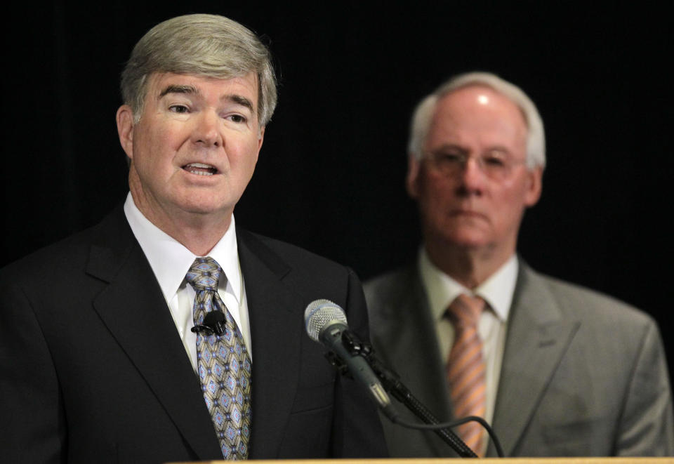 NCAA President Mark Emmert, left, announces penalties against Penn State as Ed Ray, NCAA Executive Committee chair and Oregon State University president, looks on at right, during a news conference in Indianapolis, Monday, July 23, 2012. The NCAA has slammed Penn State with an unprecedented series of penalties, including a $60 million fine and the loss of all coach Joe Paterno's victories from 1998-2011, in the wake of the Jerry Sandusky child sex abuse scandal. (AP Photo/Michael Conroy)