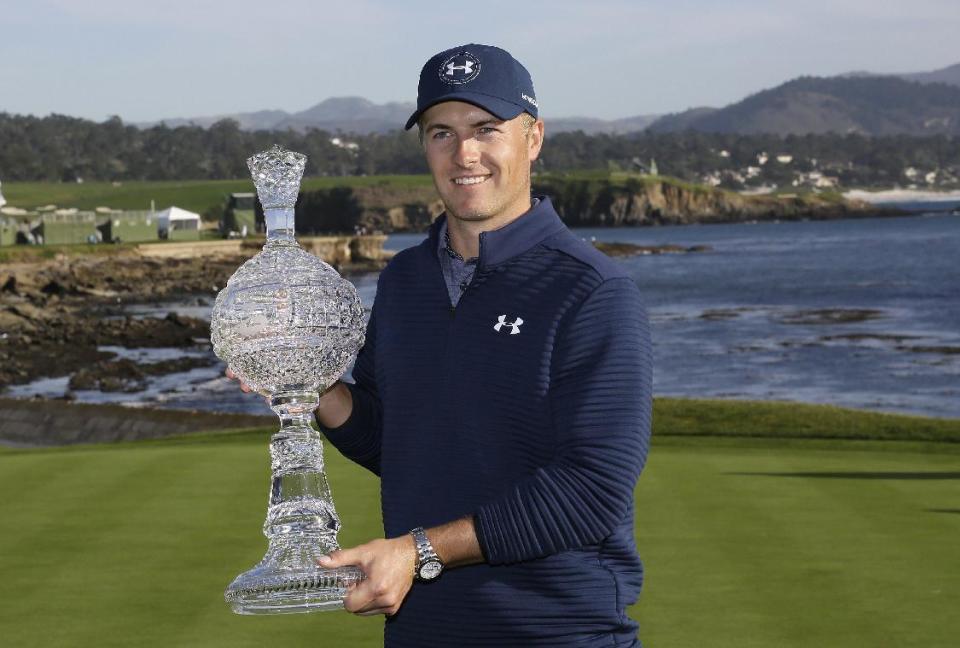 Jordan Spieth poses with his trophy on the 18th green of the Pebble Beach Golf Links after winning the AT&T Pebble Beach National Pro-Am golf tournament Sunday, Feb. 12, 2017, in Pebble Beach, Calif. (AP Photo/Eric Risberg)