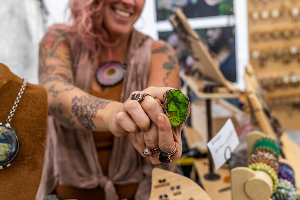 An artist showing jewelry at the DIY Street Fair in 2022.