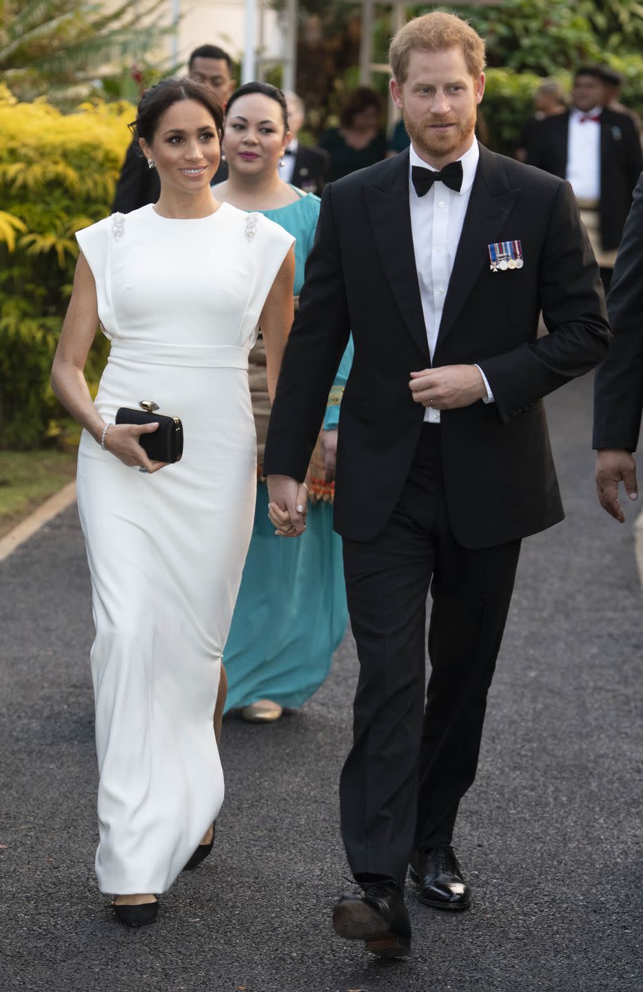 <p>Meghan wore a white column dress, featuring shoulder embellishments, for a state dinner at the royal residence in Nuku'alofa, Tonga. The visit was part of the couple's autumn<a href="https://www.townandcountrymag.com/society/tradition/a21273366/meghan-markle-prince-harry-first-royal-tour-2018/" rel="nofollow noopener" target="_blank" data-ylk="slk:tour of Australia, Fiji, Tonga, and New Zealand.;elm:context_link;itc:0;sec:content-canvas" class="link "> tour of Australia, Fiji, Tonga, and New Zealand. </a></p>