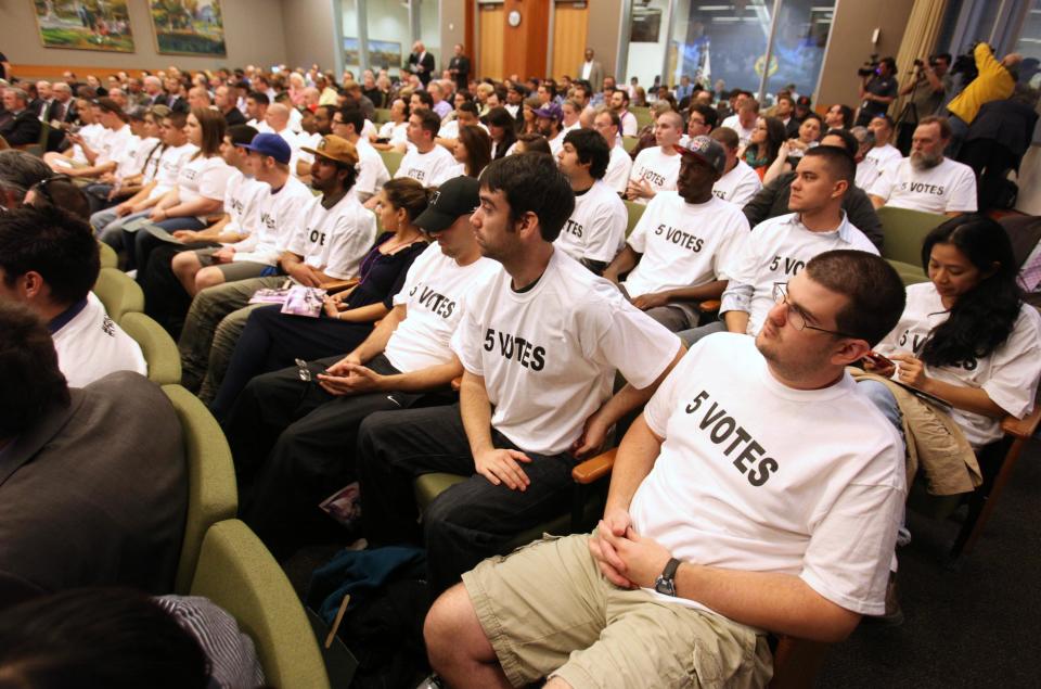 Fund Arena Now members, who support the construction of a new sports and entertainment center, attend the Sacramento City Council meeting wearing T-shirts indicating how many votes are for needed for approval of a new sports arena proposal, in Sacramento, Calif. Tuesday, March 6, 2012. A year after the NBA's Sacramento Kings almost moved to Anaheim, Sacramento's plan to help finance a new $391 million arena was a vote away from approval Tuesday night. (AP Photo/Rich Pedroncelli)