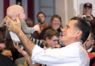 Republican presidential candidate and former Massachusetts Governor Mitt Romney holds up a baby from the audience at a campaign rally at Cleveland State University in Cleveland, Ohio March 2, 2012. REUTERS/Brian Snyder