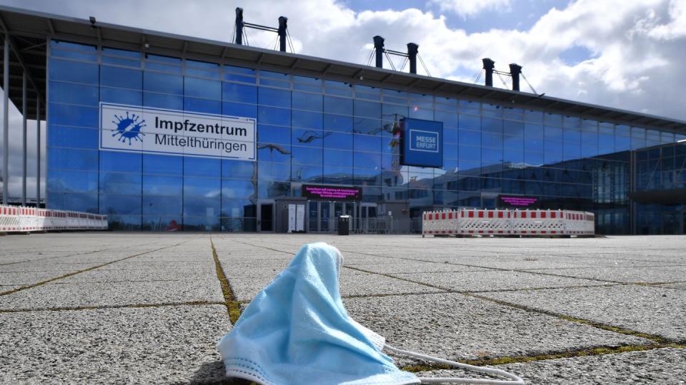 Eine Maske liegt vor dem Impfzentrum in der Messe Erfurt. In den ostdeutschen Bundesländern sind weniger Menschen gegen Covid-19 geimpft als bundesweit.