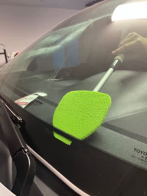 A windshield cleaning mop with a long handle