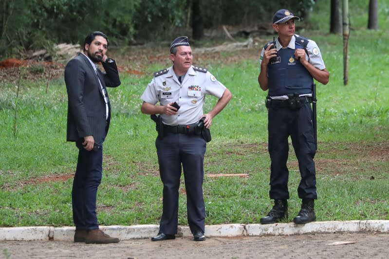 Tomas Silva, a representative of Venezuela's opposition leader Juan Guaido in Brazil, stands next to Military Police officers on the grounds of the Venezuelan embassy in Brasilia