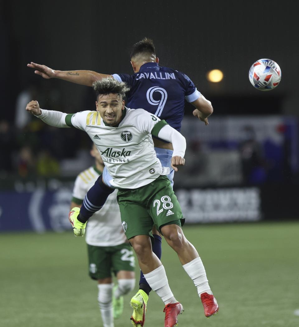 Portland Timbers defender Pablo Bonilla, left, and Vancouver Whitecaps forward Lucas Cavallini head the ball during the first half of an MLS soccer match in Portland, Ore., Wednesday, Oct. 20, 2021. (AP Photo/Steve Dipaola)