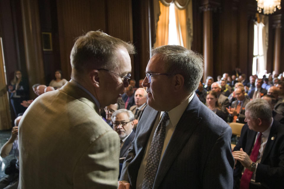 Acting White House Chief of Staff Mick Mulvaney, left, shakes hands with EPA administrator Andrew Wheeler after Wheeler signed the Affordable Clean Energy Rule at the Environmental Protection Agency, Wednesday, June 19, 2019, in Washington. Wheeler signed a repeal of one of the Obama era's two biggest climate change initiatives, the Clean Power Plan, and adopting an alternative plan that would loosen regulations on the plants. (AP Photo/Alex Brandon)
