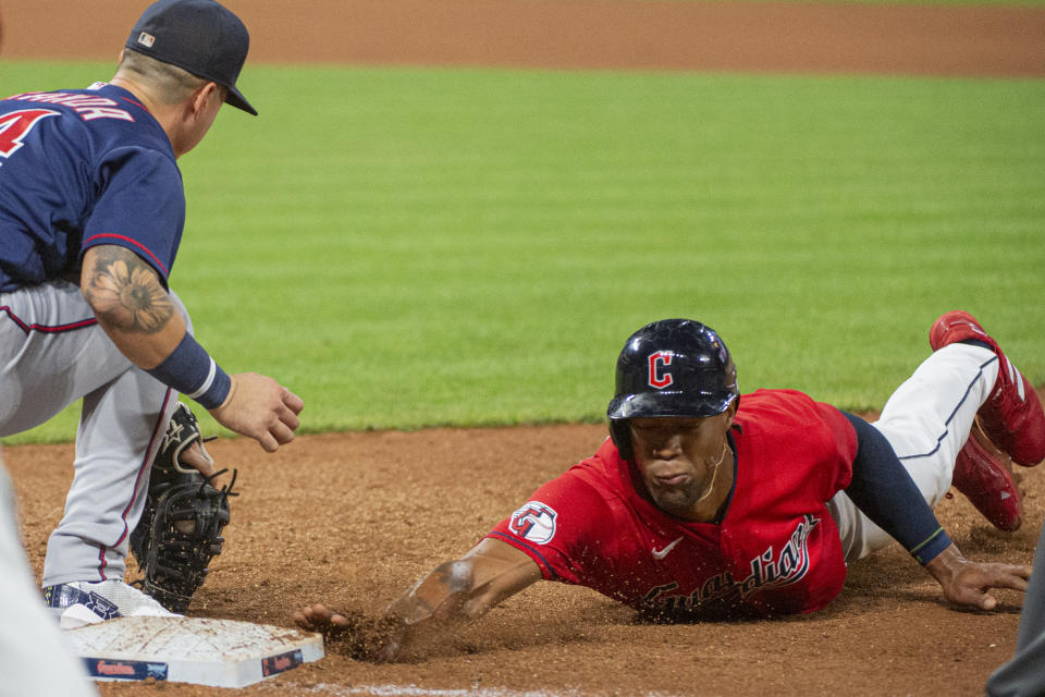 Cleveland Guardians' Will Benson, right, dives safely back to first base, beating a tag by Minnesota Twins' Jose Miranda, during the fifth inning of the second game of a baseball doubleheader in Cleveland, Saturday, Sept. 17, 2022. (AP Photo/Phil Long)