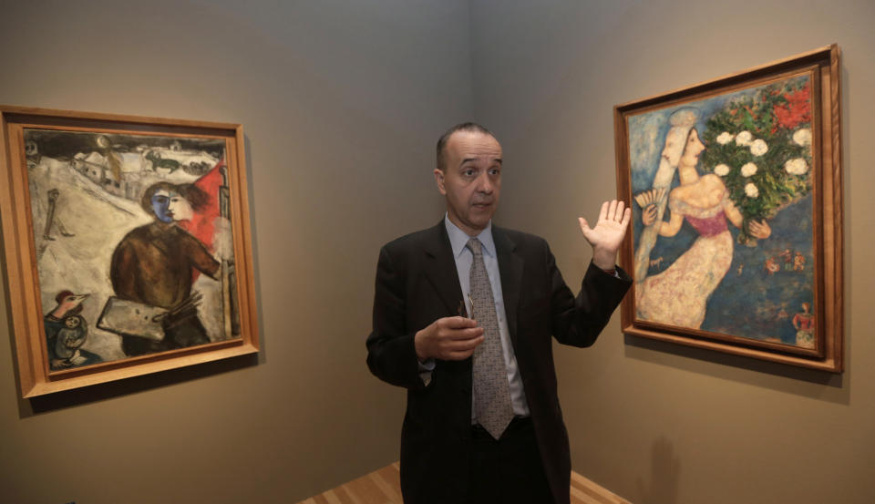 In this photo taken Feb. 13, 2013, museum curator Olivier Meslay talks about paintings by artist Marc Chagall included in the "Chagall: Beyond Color," exhibit during a preview at the Dallas Museum of Art Wednesday, Feb. 13, 2013, in Dallas. This will be the only U.S. venue to host the exhibit that opens to the public on Sunday. (AP Photo/LM Otero)