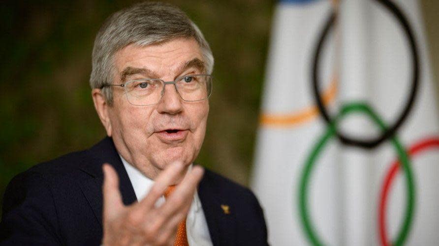 Thomas Bach with the Olympic flag