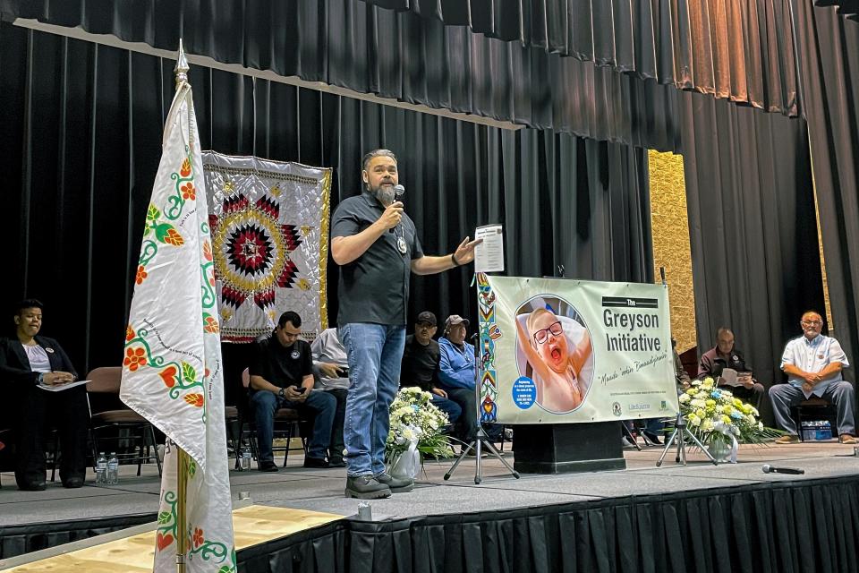 In this photo provided by LifeSource, Turtle Mountain Band of Chippewa Indians Chairman Jaime Azure unveils a tribal ID that has a spot to designate organ donation, Monday, Nov. 14, 2022, in Belcourt, N.D.. Tribal member Greyson Parisien's journey to correct a heart defect inspired the change. (Mike Hutto/LifeSource via AP)