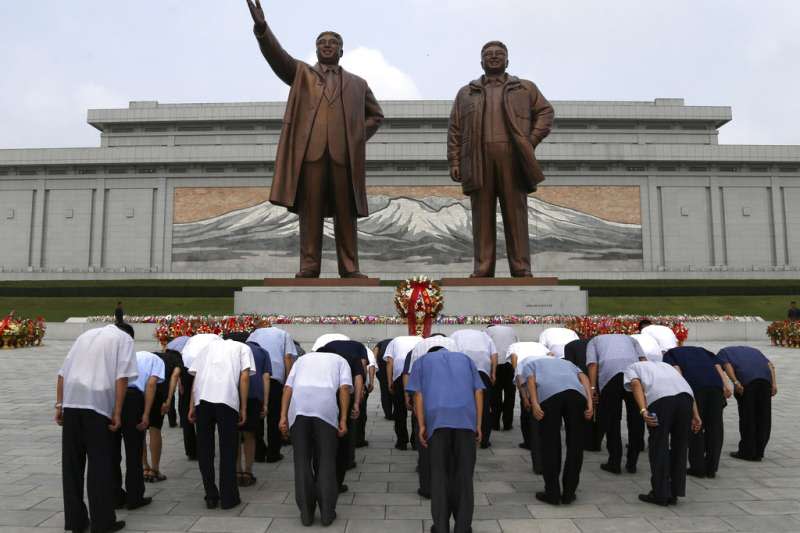 2018年7月27日，韓戰停戰協定簽署65周年，北韓民眾在金正日與金日成的平壤銅像前鞠躬。（AP）