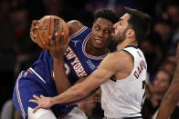 New York Knicks guard RJ Barrett (9) drives into Denver Nuggets guard Facundo Campazzo during the first half of an NBA basketball game Saturday, Dec. 4, 2021, in New York. (AP Photo/Adam Hunger)