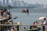 <p>A participant jumps into a lake with a bike during a local event to call on residents to protect the environment in Wuhan, Hubei Province, China, July 24, 2016. (Photo: China Daily/REUTERS)</p>