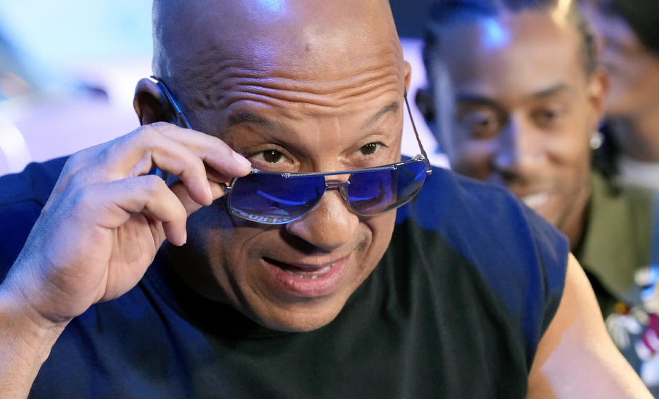 Vin Diesel, a cast member in the upcoming film "Fast X," peers over his sunglasses at photographers at the trailer launch for the film, Thursday, Feb. 9, 2023, at L.A. Live in Los Angeles. (AP Photo/Chris Pizzello)