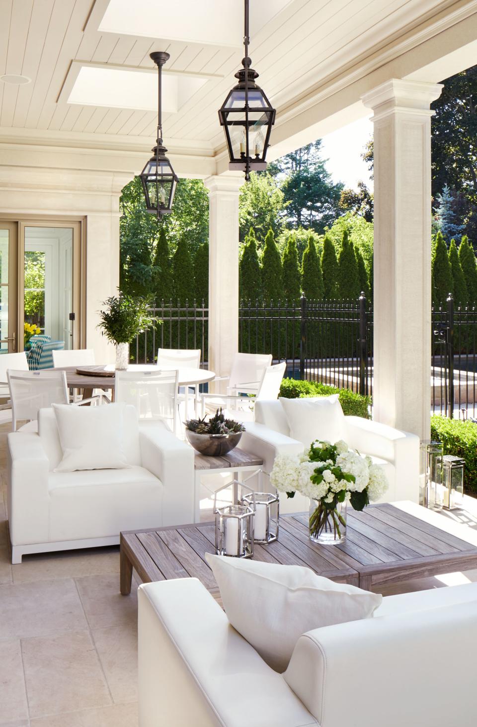 Hepfer chose natural pieces for the backyard loggia, from the travertine tile floors to the simple white chairs by Jardin de Ville, to complement the gorgeous garden views.