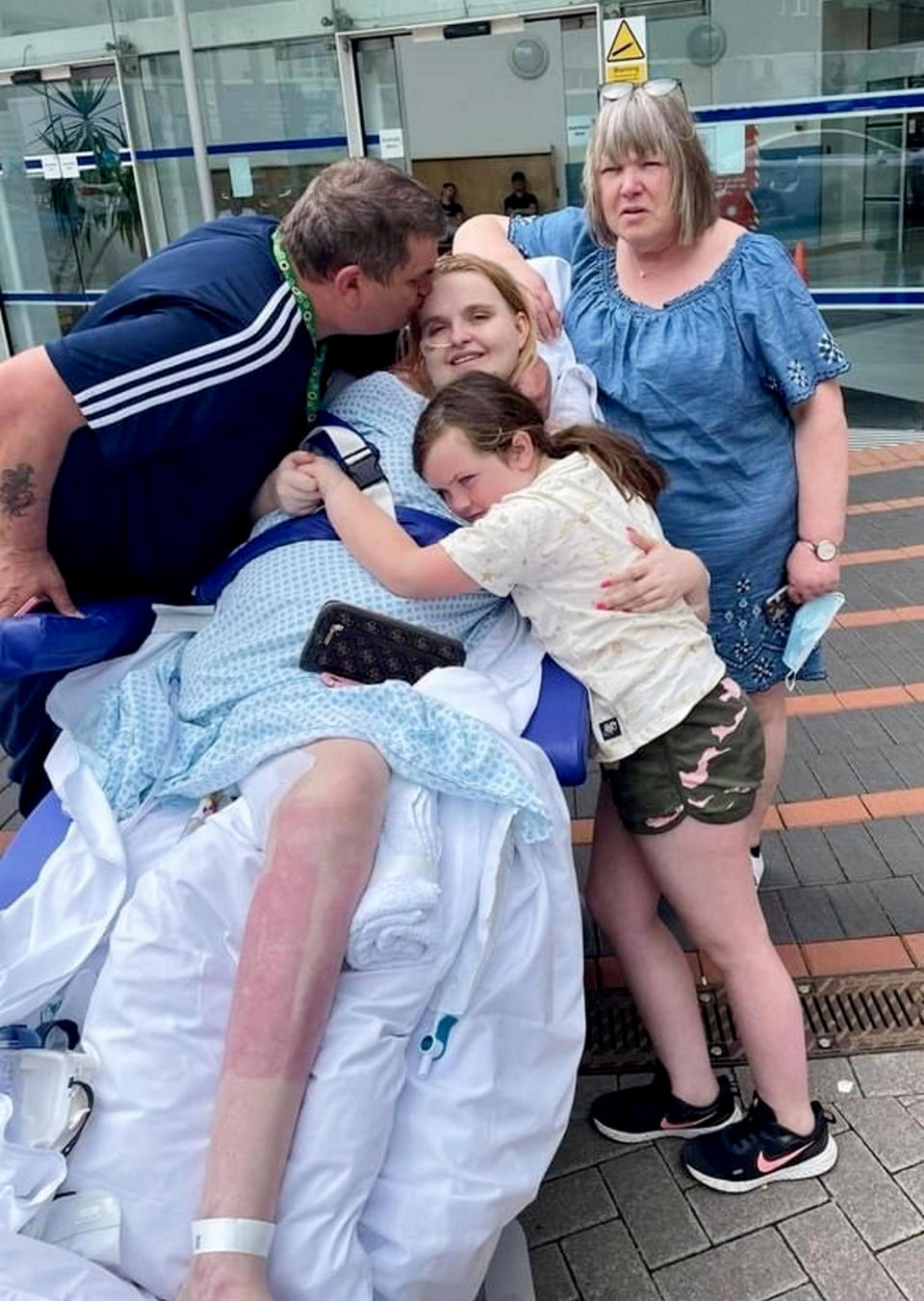 Lucie with her family outside the hospital where she recovered for over 500 days. (Day One Trauma Support/SWNS)