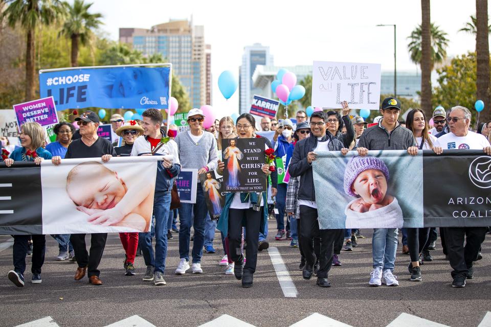 A crowd walks down Washington Street towards the Arizona State Capitol during the Arizona for Life march and rally in Phoenix on Jan. 15, 2022.