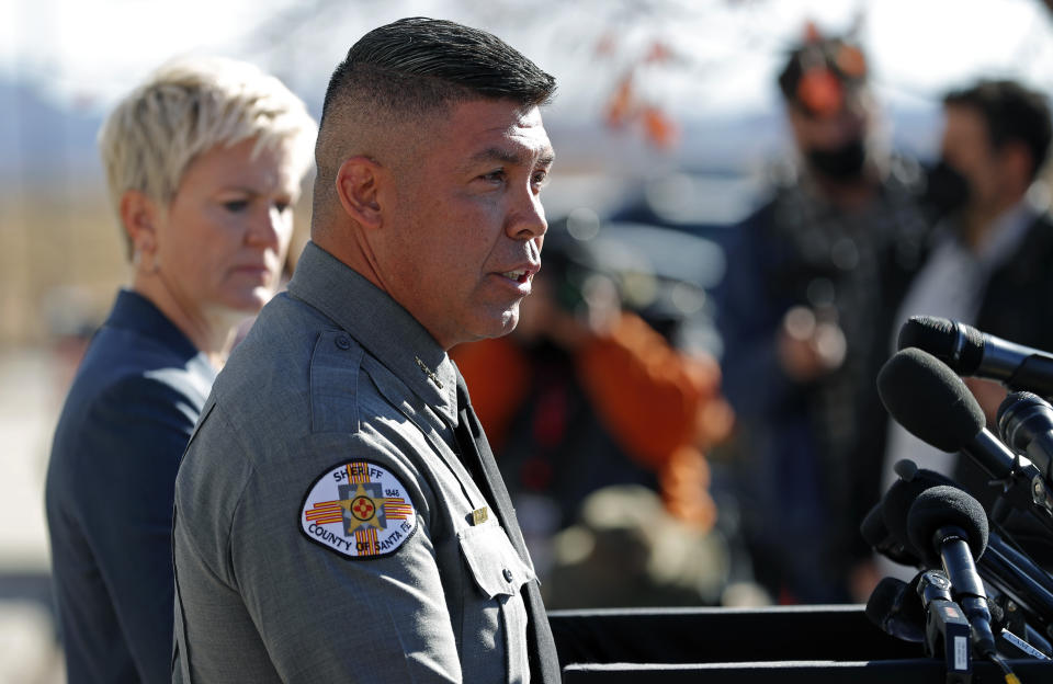 Santa Fe County Sheriff Adan Mendoza, front, speaks Santa Fe District Attorney Mary Carmack-Altwies, rear, listens during a news conference in Santa Fe, N.M., Wednesday, Oct. 27, 2021. New Mexico authorities said Wednesday they have recovered a lead projectile believed to have been fired from the gun used in the fatal movie-set shooting. (AP Photo/Andres Leighton)