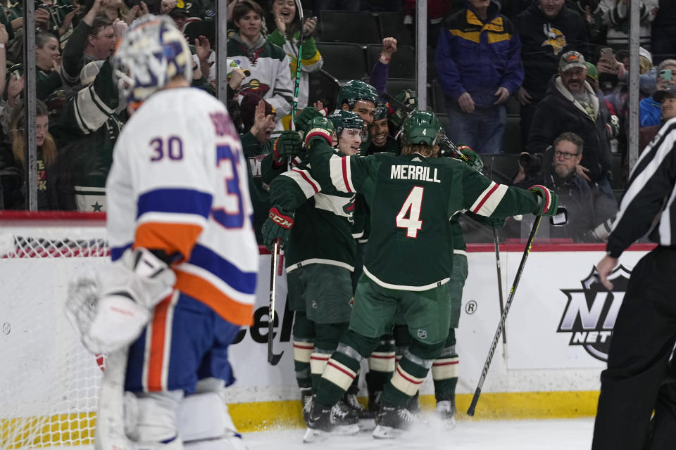 Minnesota Wild right wing Ryan Reaves, middle, celebrates with teammates after scoring a goal against New York Islanders goaltender Ilya Sorokin (30), left, during the first period of an NHL hockey game Tuesday, Feb. 28, 2023, in St. Paul, Minn. (AP Photo/Abbie Parr)