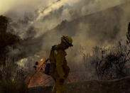 <p>A firefighter keeps watch a wildfire along a hillside in Azusa, Calif., Monday, June 20, 2016. Police in the city of Azusa and parts of Duarte ordered hundreds of homes evacuated. Others were under voluntary evacuations. (AP Photo/Ringo H.W. Chiu) </p>