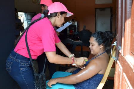 A health worker sprays mosquito repellent on a pregnant woman's arm, during a campaign to fight the spread of Zika virus in Soledad municipality near Barranquilla, Colombia, in this February 1, 2016 handout photo supplied by the Soledad Municipality. REUTERS/Aleydis Coll/Soledad Municipality/Handout via Reuters