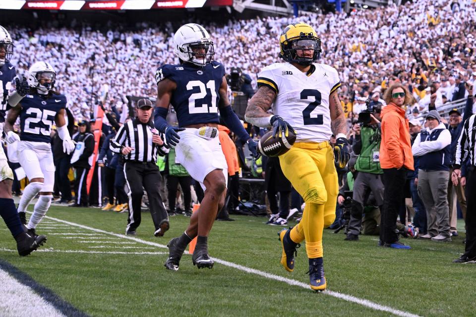 Michigan running back Blake Corum scores a touchdown as Penn State defenders Kevin Winston Jr. (21) and Daequan Hardy (25) pursue him during the second half of U-M's 24-15 win on Saturday, Nov. 11, 2023, in University Park, Pennsylvania.