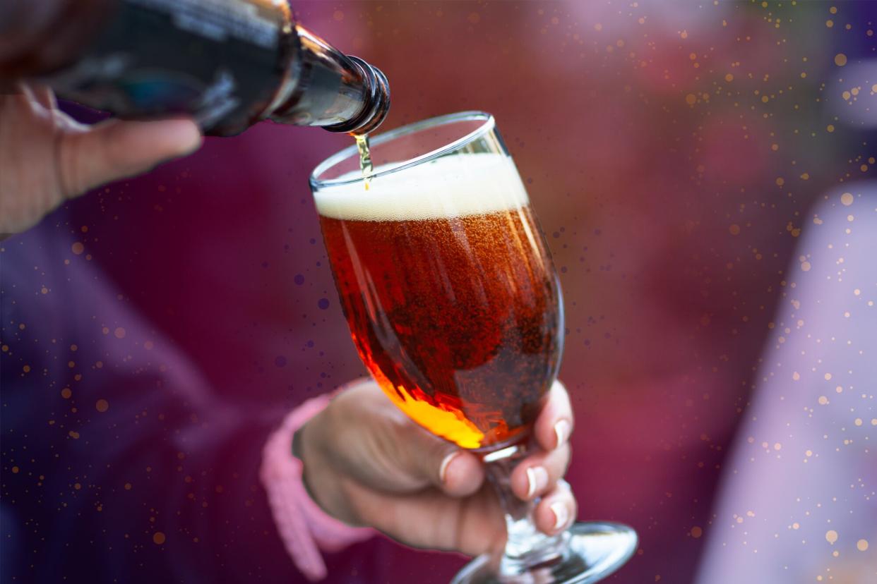 hands pouring beer from a bottle on a designed background