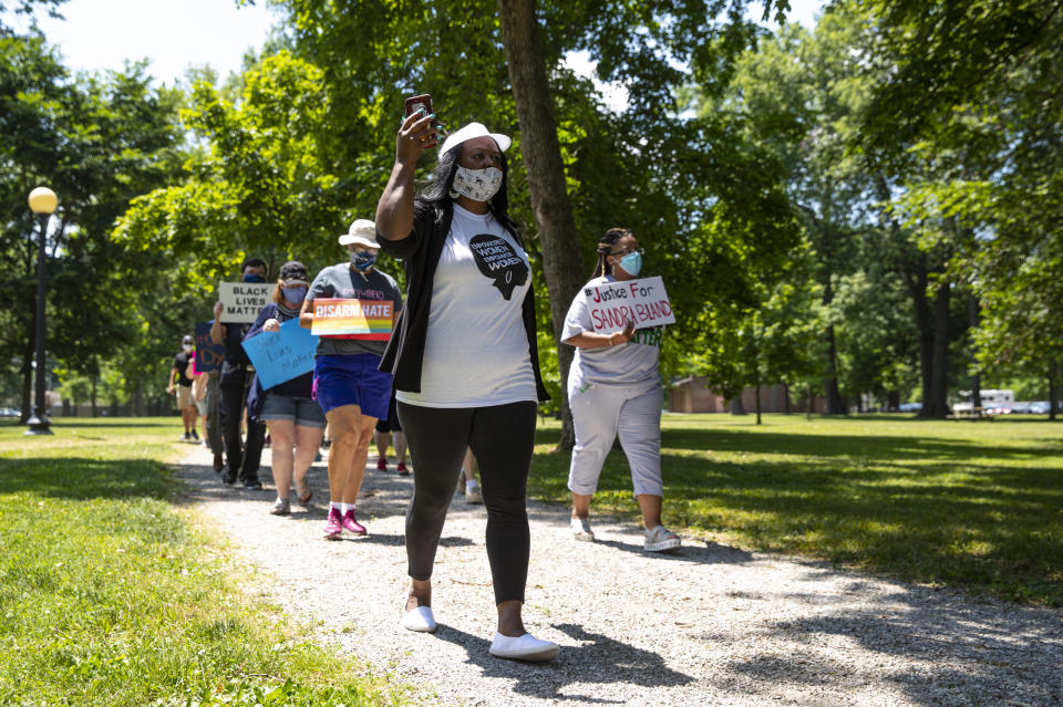 In this Friday, June 19, 2020, photo Jeannine Lee Lake, Democratic candidate for Indiana's 6th congressional district, leads a march to honor George Floyd during a Juneteenth day event in Columbus, Ind. Lake never would have imagined when she first ran against Greg Pence, Vice President Mike Pence's brother, for a rural Indiana congressional seat two years ago: An almost entirely white crowd of more than 100 people marching silently in the Pences' hometown, sending up prayers for Black people killed by police and an end to systemic racism. Leading them was Lake, who has launched a rematch against Pence. She is the only Black woman running for federal office in Indiana this fall. (AP Photo/Michael Conroy)