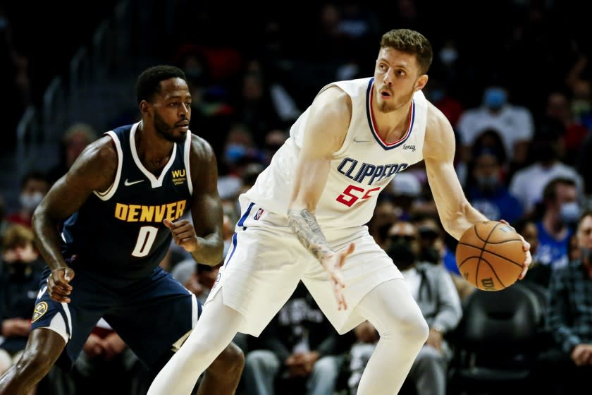 Los Angeles Clippers Center Isaiah Hartenstein, right, is defended by Denver Nuggets forward JaMychal Green (0) during the first half of a preseason NBA basketball game, Monday, Oct. 4, 2021, in Los Angeles. (AP Photo/Ringo H.W. Chiu)