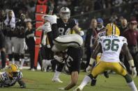 Aug 24, 2018; Oakland, CA, USA; Oakland Raiders running back Chris Warren (34) is upended as Green Bay Packers defensive back Raven Greene (36) watches during a preseason game at Oakland-Alameda County Coliseum. Mandatory Credit: Kirby Lee-USA TODAY Sports