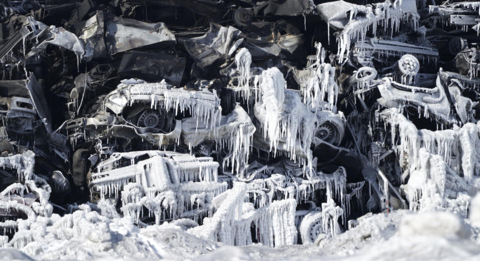 The massive fire at Northern Metal recycling in Becker, Minnesota, that has been burning for days, seemed to be under control Thursday, Feb. 20, 2020 with massive piles of burned cars covered in ice. The Becker Police Department posted Thursday that “major progress" has been made and that fire crews report the fire is “under control at this point.” (Brian Peterson/Star Tribune via AP)