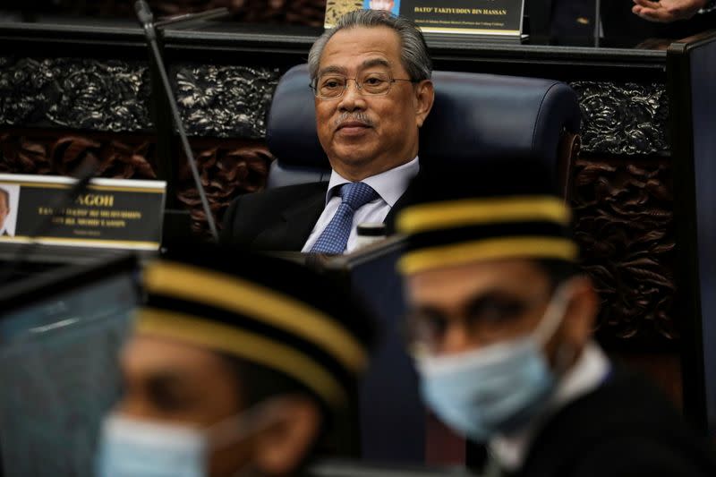 FILE PHOTO: Malaysia's Prime Minister Muhyiddin Yassin reacts during a session of the lower house of parliament, in Kuala Lumpur