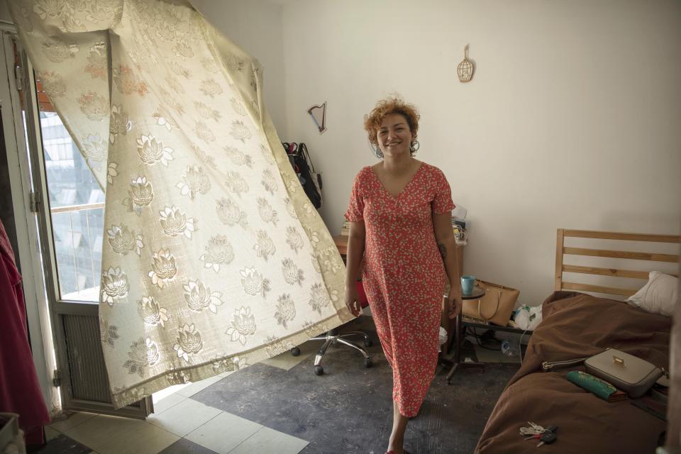 Basma Mostafa, a 30-year-old journalist who founded an initiative that sends freshly home cooked meals to quarantined coronavirus patients, gets from fresh air before packaging food at her friend's apartment, in Cairo, Egypt. Saturday, July 11, 2020. Mostafa, who works with others to coordinate the volunteer effort, said she got the idea of helping out when she was going through a difficult time. "I thought that to alleviate my suffering, I can engage with the suffering of others and feel more for them," she said. "I derive my strength and perseverance from the patients." (AP Photo/Nariman El-Mofty)