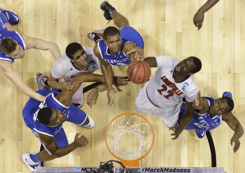 Kentucky's Dakari Johnson (44), Aaron Harrison (2) and Dominique Hawkins (25) go after a rebound with Louisville's Wayne Blackshear (20) and Akoy Agau (22) during the first half of an NCAA Midwest Regional semifinal college basketball tournament game Friday, March 28, 2014, in Indianapolis. (AP Photo/Michael Conroy)