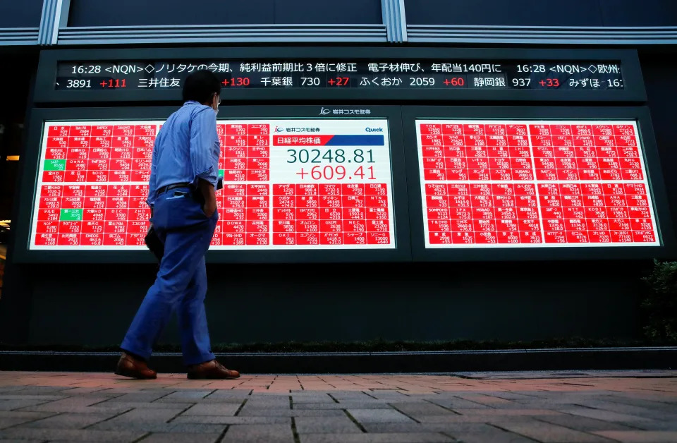 A man wearing a protective face mask amid the coronavirus disease (COVID-19) outbreak, looks at an electronic board displaying Japan&#39;s Nikkei Index outside a brokerage in Tokyo, Japan, September 24, 2021. REUTERS/Kim Kyung-Hoon