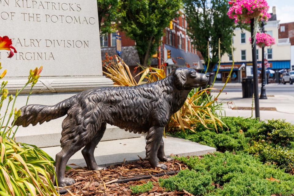 "Iron Mike," a cast iron statue of a dog commissioned by George Washington Welsh in the 1800s, stands beside "The Pickett" that honors the Battle of Hanover, as seen in center square, Thursday, June 27, 2024, in Hanover Borough.