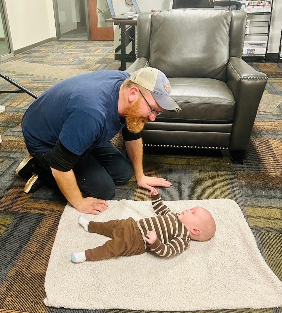 Jared Lennert, 39, plays with his 4-month-old Jared Jr. Dec. 7, while his daughters, Rosemary, 9, and Tegan, 7, take ballet classes at Above the Clouds at 2431 N. Teutonia Ave. The non-profit offers free classes to young people in ballet, martial arts, spoken word, jazz and piano