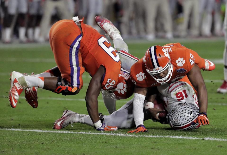 Clemson defensive end Clelin Ferrell (99) sacks Ohio State quarterback J.T. Barrett (16) as defensive end Richard Yeargin (49) falls on Barrett during the second half of the Fiesta Bowl NCAA college football playoff semifinal, Saturday, Dec. 31, 2016, in Glendale, Ariz. (AP Photo/Rick Scuteri)