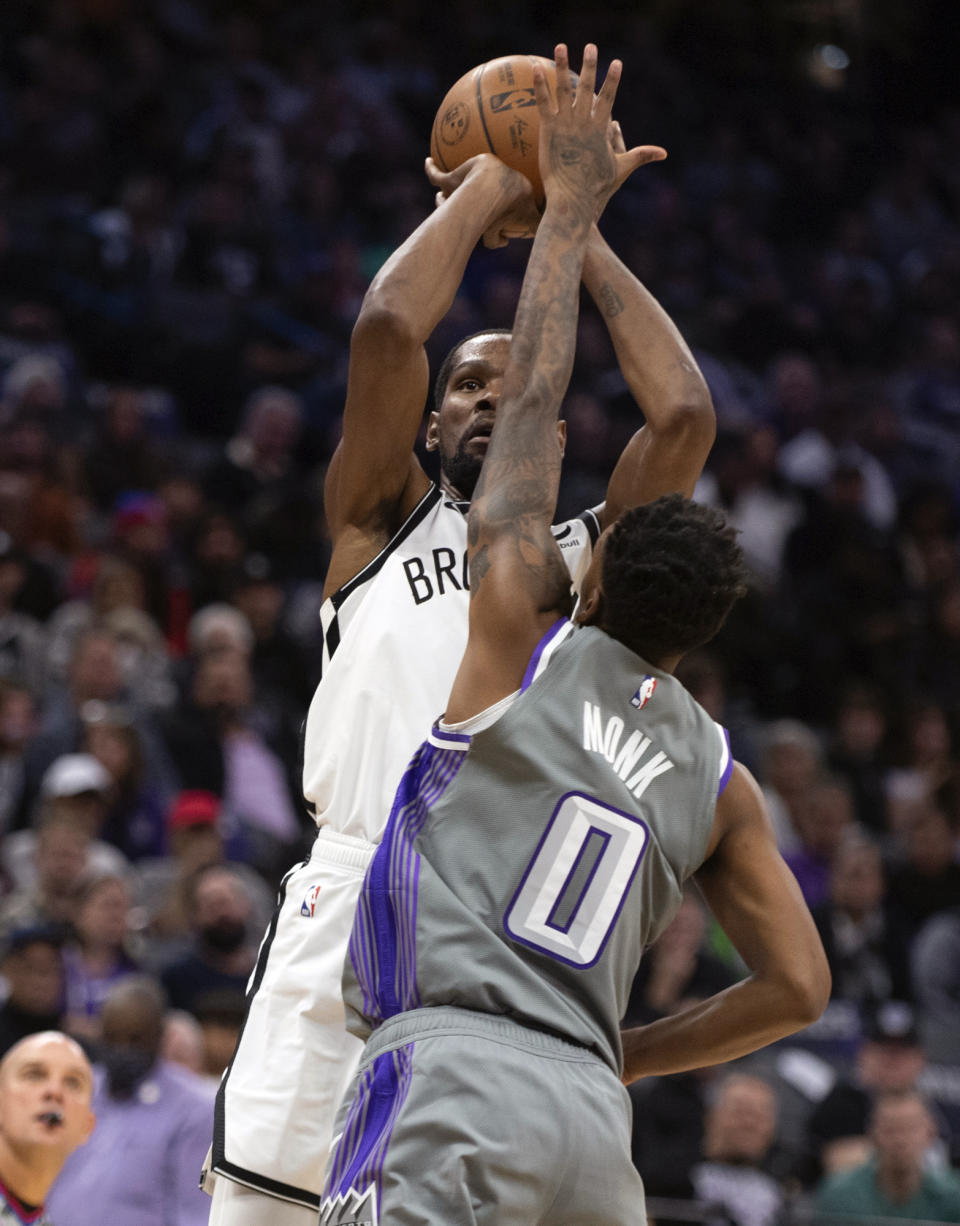 Brooklyn Nets forward Kevin Durant (7) shoots over Sacramento Kings guard Malik Monk (0) in the first quarter of an NBA basketball game in Sacramento, Calif., Tuesday, Nov. 15, 2022. (AP Photo/José Luis Villegas)