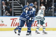 Toronto Maple Leafs' Mitchell Marner, left, celebrates with Auston Matthews after scoring an empty-net goal against the San Jose Sharks during the third period of an NHL hockey game Wednesday, Nov. 30, 2022, in Toronto. (Chris Young/The Canadian Press via AP)