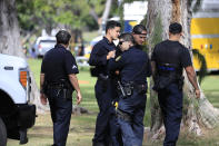 Honolulu police officers gather near the scene of a shooting near Diamond Head State Monument on Sunday, Jan. 19, 2020, in Honolulu. (AP Photo/Marco Garcia)