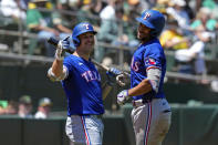 Texas Rangers' Marcus Semien, right, celebrates with Nathaniel Lowe after hitting a solo home run against the Oakland Athletics during the third inning in the first baseball game of a doubleheader Wednesday, May 8, 2024, in Oakland, Calif. (AP Photo/Godofredo A. Vásquez)