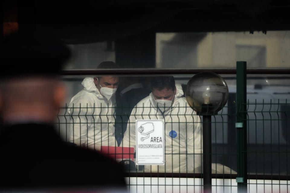 Forensic police officers inspect a bar where three people died after a man entered and shot in Rome, Sunday, Dec. 11, 2022. (AP Photo/Gregorio Borgia)