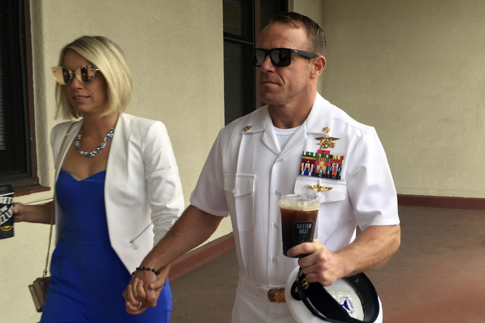 Navy Special Operations Chief Edward Gallagher, right, walks with his wife, Andrea Gallagher as they arrive to military court on Naval Base San Diego, Wednesday, June 26, 2019, in San Diego. Trial continues in the court-martial of the decorated Navy SEAL, who is accused of stabbing to death a wounded teenage Islamic State prisoner and wounding two civilians in Iraq in 2017. He has pleaded not guilty to murder and attempted murder, charges that carry a potential life sentence. (AP Photo/Julie Watson)